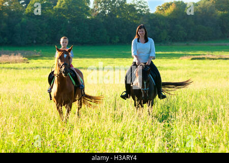 Reitstunden - Frau entlang ein Junge auf einem Pferd Reiten Stockfoto