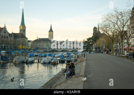 Zürich, Schweiz - 27. Dezember 2015: Sonnenuntergang Blick auf dem Westufer des Flusses Limmat mit der St. Peter und Fraumünster Ch Stockfoto