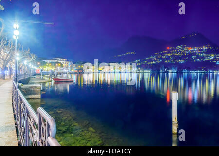 LUGANO, Schweiz - 29. Dezember 2015: Abend Blick auf die Seepromenade mit Weihnachtsschmuck, einheimische und Besucher Stockfoto