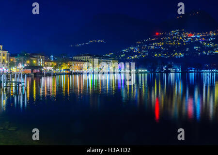 LUGANO, Schweiz - 29. Dezember 2015: Abend Blick auf die Seepromenade mit Weihnachtsschmuck, einheimische und Besucher Stockfoto