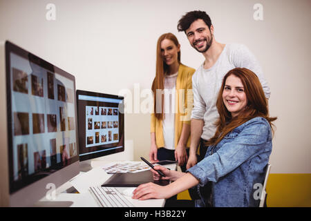 Porträt des Lächelns Foto-Editoren mit Computern Stockfoto