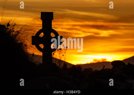 Silhouette des keltischen Kreuzes bei Sonnenuntergang auf der Dingle-Halbinsel im County Kerry, Irland Stockfoto