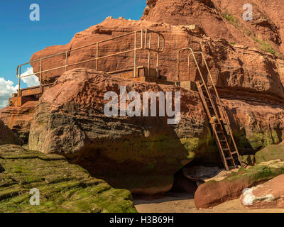 Rustikale Felsformationen sichtbar bei Ebbe und rostenden Metall Gänge an Orcome Stelle in der Nähe der Küste Stadt Exmouth, Devon. Stockfoto