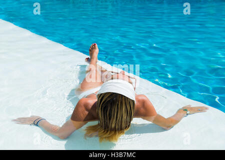 Frau mit Kopftuch Sonnenbaden am pool Stockfoto