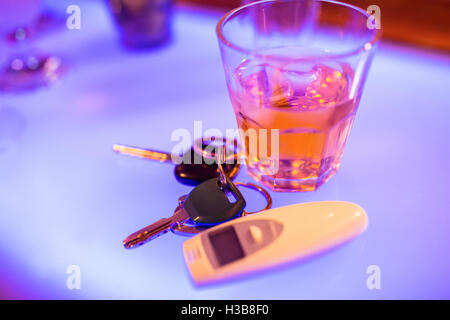 Alkohol-Glas mit Autoschlüssel am Zähler Stockfoto