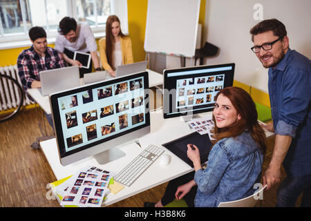 Porträt des Lächelns Foto-Editoren, die Arbeit am Computer Stockfoto