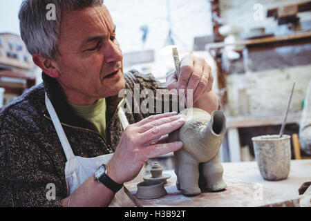 Reifen Mann Ton Elefanten konzentriert Stockfoto