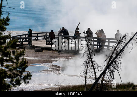 Besucher am Boardwalk anzeigen Geysire und Kochen Pools Federn in West Thumb Yellowstone Nationalpark, Wyoming, USA. Stockfoto