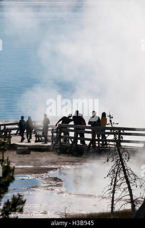 Besucher am Boardwalk anzeigen Geysire und Kochen Pools Federn in West Thumb Yellowstone Nationalpark, Wyoming, USA. Stockfoto