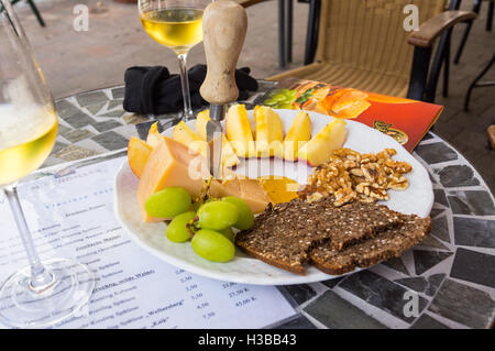 Ein Teller mit litauischen "Dziuga" Käse und Roggenbrot mit einem Glas Riesling-Wein, Weingut Schömann, Zeltingen, Mosel, Deutschland Stockfoto