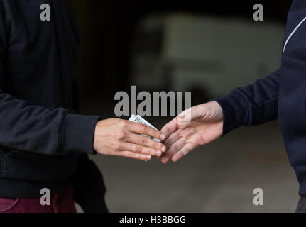 Nahaufnahme eines Süchtigen zahlen Geld für Drogendealer Stockfoto