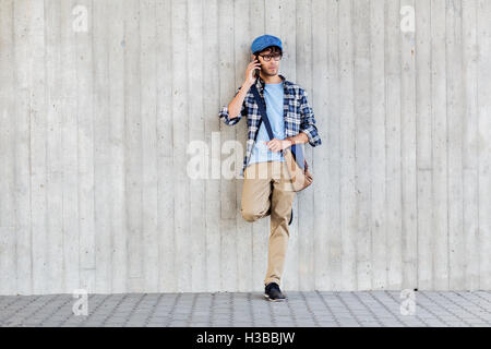 Mann mit Tasche fordert Smartphone an Straße Wand Stockfoto