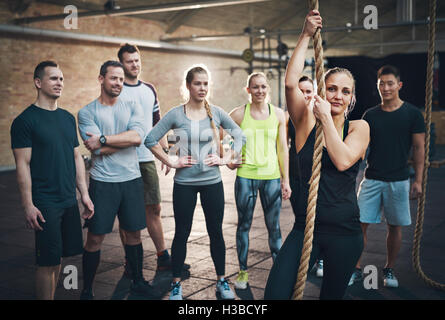 Gruppe von Erwachsenen Frau Verwendung Kletterseil in Fitness Übungsprogramm Circuit Training beobachten Stockfoto