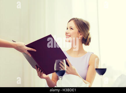 lächelnde Frau empfangende Menü von Kellner Stockfoto