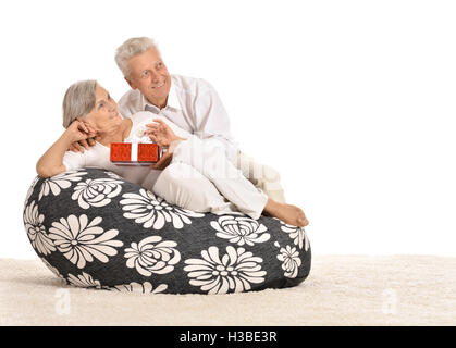 Paar in Sessel mit Geschenk Stockfoto