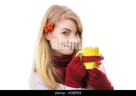 Glücklich lächelndes Mädchen mit Rowan im Haar tragen Wolle Schal und Handschuhe, Tasse Tee mit verpackt Schal, Erwärmung trinken, Stockfoto