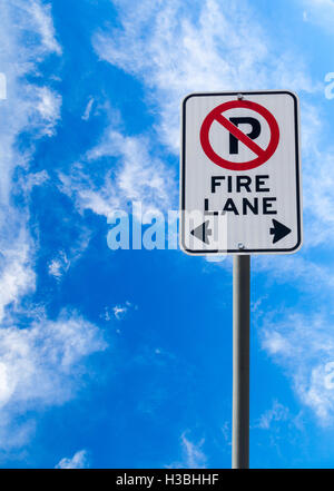 Ein Feuer Lane No Parking Zeichen vor einem blauen bewölkten Himmel mit Textfreiraum. Vertikale Ausrichtung. Stockfoto