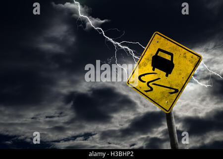 Rutschig wenn nass Straßenschild vor dem stürmischen Hintergrund mit Blitz und kopieren Raum. Schmutzig und abgewinkelte Zeichen verleiht dem Drama. Stockfoto