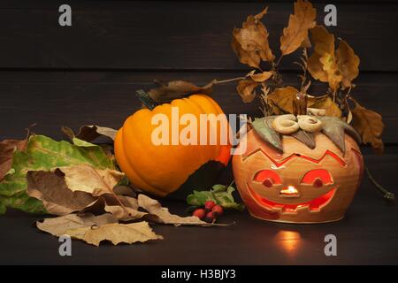 Halloween-Kürbis Party, großen schrecklichen Kürbis zu erleichtern und die Reflexion über hölzerne Tabelle Hintergrund. Stockfoto