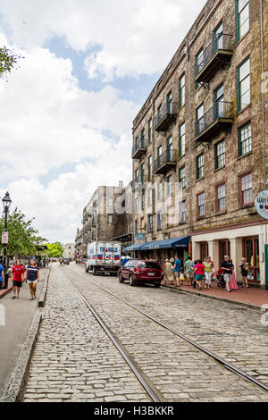 Blick auf die Geschäfte River Street in Savannah mit Trolley Tracks in Kopfsteinpflaster Stockfoto