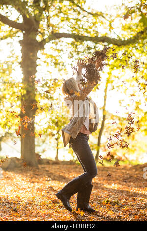 Frau Herbst Blätter im Wald auf sonnigen Tag Stockfoto