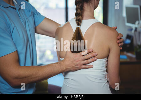 Physiotherapeuten massieren des Rückens einer Patientin Stockfoto