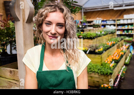 Lächelnde weibliche Florist stehend im Garten-center Stockfoto