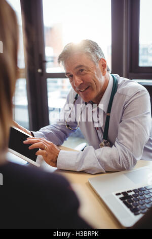 Arzt diskutieren mit Patienten über digital-Tablette Stockfoto