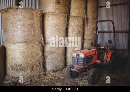 Heuballen und Traktor in der Scheune Stockfoto