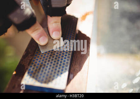 Des Tischlers Hand schärfen Meißel auf Stein Stockfoto