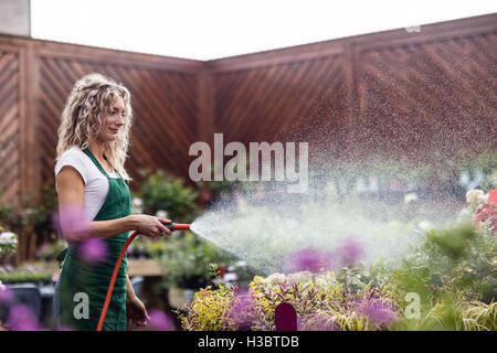 Blumengeschäft sprühen Wasser auf Pflanzen Stockfoto