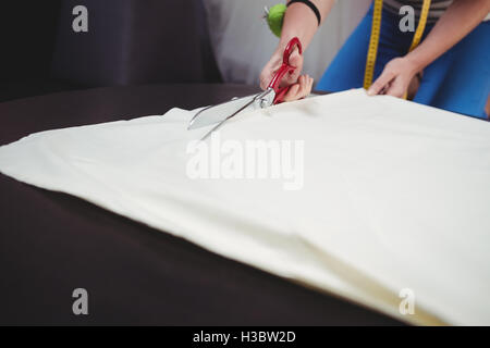 Weibliche Mode-Designer einen weißen Stoff schneiden Stockfoto
