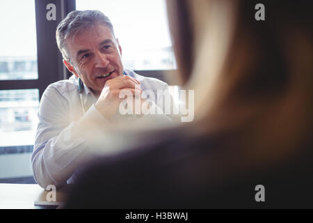 Arzt sitzt an seinem Schreibtisch im Gespräch mit Patienten Stockfoto