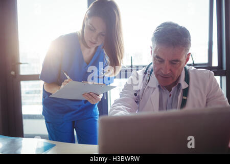 Arzt diskutieren mit Krankenschwester über laptop Stockfoto