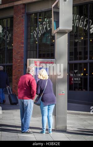 Mann & Frau mit Blick auf große Outdoor Straßenkarte, Information Point in Manchester City Centre, UK Stockfoto