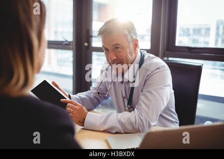 Arzt diskutieren mit Patienten über digital-Tablette Stockfoto