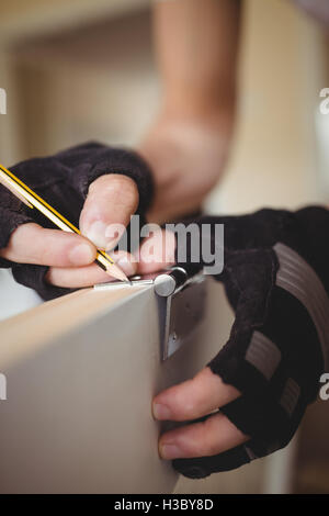 Zimmermanns Hände an Tür mit Bleistift markieren Stockfoto