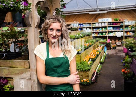 Lächelnde weibliche Florist stehend im Garten-center Stockfoto