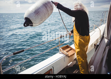 Fischer eine Boje ins Meer werfen Stockfoto