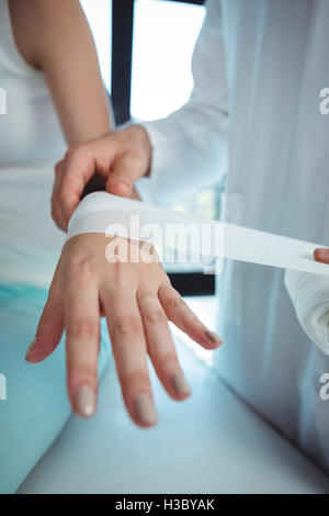 Männlichen Therapeuten weiblichen Patienten Hand Bandage anziehen Stockfoto