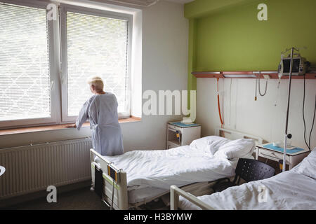 Ältere Frau stehen in der Nähe von Fenster Stockfoto