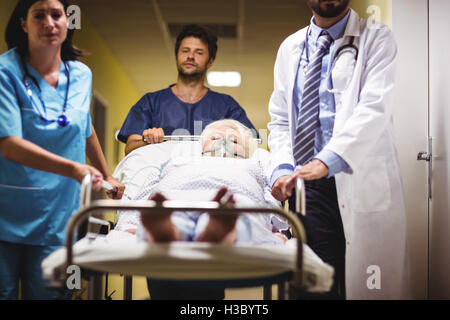 Arzt und Krankenschwester schob ein senior Patient auf Keilrahmen Stockfoto