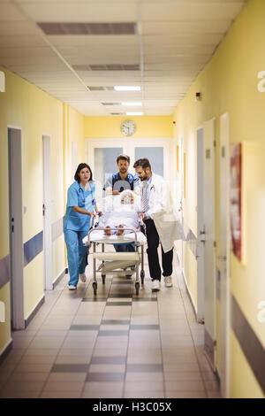 Arzt und Krankenschwester schob ein senior Patient auf Keilrahmen Stockfoto