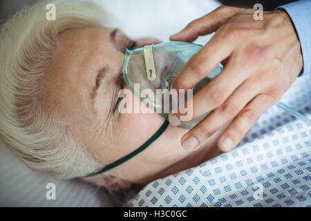 Arzt die Sauerstoffmaske auf Patienten Stockfoto