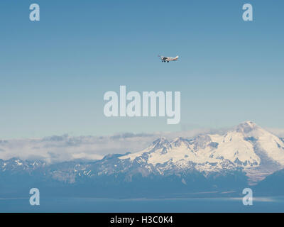 Eine Tourist-Flugzeug fliegt vor dem Vulkan Mount Iliamna über Cook Inlet, Alaska. Stockfoto