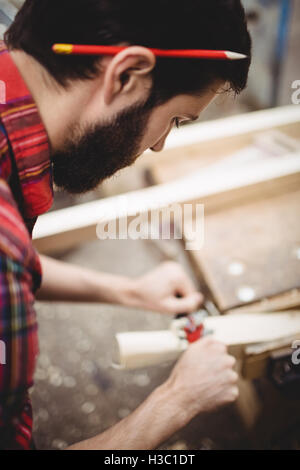 Mann mit einem handheld Werkzeug zum Glätten und ebnen die Oberfläche eine Planke Stockfoto