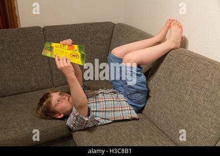 kleiner Junge liest ein Buch Stockfoto