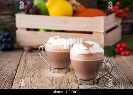 Hausgemachte Zimt und Gewürzen serviert heiße Schokolade mit Sahne. Thanksgiving-Tischdekoration Stockfoto
