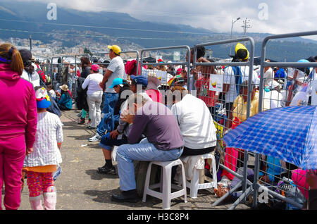 QUITO, ECUADOR - 7. Juli 2015: Ein paar ältere Leute sitzen in der Mitte der Mass, beten unter der Sonne Stockfoto