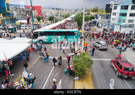 QUITO, ECUADOR - 7. Juli 2015: Autos eine Busse versucht, mitten in einer belebten Straßen, Passanten ankommen, um Papst Fransisco Masse zu überholen Stockfoto